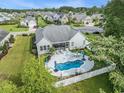 Aerial view of private backyard oasis with pool, screened porch, mature trees, and fenced yard at 2010 Chattooga Ct., Myrtle Beach, SC 29588