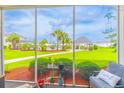 Serene screened patio featuring lush green landscaping and a glimpse of community amenities at 2060 Cross Gate Blvd. # 102, Surfside Beach, SC 29575