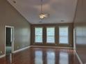 Bright living room with ceiling fan, vaulted ceiling, laminate floors, and natural light from three large windows at 244 Colby Ct., Myrtle Beach, SC 29588