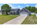 Attractive home with gray siding, a two-car garage, and a long driveway on a sunny day at 250 Penn Circle, Galivants Ferry, SC 29544