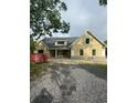 Beautiful exterior with yellow vertical siding and black framed windows; featuring a spacious gravel driveway at 287 All Saints Loop, Pawleys Island, SC 29585