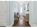 Bright entryway boasts hardwood floors, light-blue walls, and a charming accent chair at 308 Firenze Loop, Myrtle Beach, SC 29579