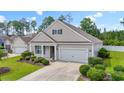 Beautiful single-story home featuring a well-manicured lawn, landscaping, and a two-car garage at 308 Firenze Loop, Myrtle Beach, SC 29579