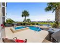 A beautifully designed pool with a hot tub and patio area, set against the backdrop of a lake at 337 St. Julian Ln., Myrtle Beach, SC 29579