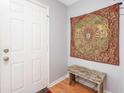 Cozy entryway featuring laminate wood floors, a rustic bench and a decorative wall hanging at 3700 Golf Colony Lane # 26A, Little River, SC 29566
