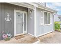 Inviting front entrance featuring nautical decor, white trim, and a secure storm door at 3700 Golf Colony Lane # 26A, Little River, SC 29566