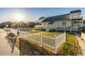 Exterior shot showcasing the home's fenced yard, inviting deck, and upper-level balconies at 4806 S Ocean Blvd., Surfside Beach, SC 29575