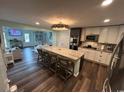 Open kitchen with an expansive island, barstool seating, stainless appliances, and hardwood floors at 4806 S Ocean Blvd., Surfside Beach, SC 29575