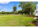 Large grassy backyard next to a black metal fence and mature trees, offering an outdoor space at 503 20Th Ave. N # 29-C, North Myrtle Beach, SC 29582