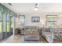 Open-concept living room with stylish furnishings, a ceiling fan, and access to a screened lanai overlooking the pond at 537 White River Dr. # 17C, Myrtle Beach, SC 29579