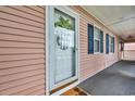 Charming front door with pineapple decor, painted in pastel colors, next to windows with blue shutters at 627 Waterway Village Blvd. # 8E, Myrtle Beach, SC 29579