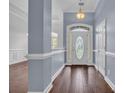 Elegant foyer with rich hardwood floors, wainscoting, and a decorative glass front door, creating a grand entrance at 760 Carolina Farms Blvd., Myrtle Beach, SC 29579