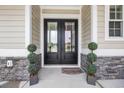 Elegant double front door with glass panels, flanked by topiaries, creating a welcoming entrance at 1024 Pochard Dr., Conway, SC 29526