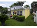 The exterior of this yellow house is enhanced by well-maintained landscaping, a grill, and charming hanging flower baskets at 12 Century St. # 12, Myrtle Beach, SC 29577