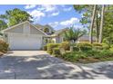 Charming single-story home featuring a manicured lawn and attached two-car garage at 1208 Trisail Ln, North Myrtle Beach, SC 29582