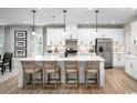 Bright, modern kitchen with white cabinets, stainless steel appliances and an island with barstool seating at 1408 Whistling Straits Way, Sunset Beach, NC 28468