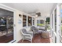 Cozy screened porch features tile floors, fan, hanging swing and chairs, perfect for relaxation at 1416 Edge Dr., North Myrtle Beach, SC 29582