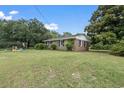 A view of the home's brick exterior, set among green lawns and some trees at 169 Ole Maple St., Loris, SC 29569