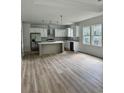Modern kitchen with stainless steel appliances, white cabinets, gray backsplash, and wood-look floors in a bright open layout at 2075 Lees Landing Circle, Conway, SC 29526