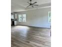 Bright living room with wood-look floors, white walls, tray ceiling, and multiple windows that let in natural light at 2075 Lees Landing Circle, Conway, SC 29526