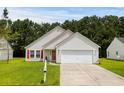 Inviting single-Gathering home featuring a well-kept lawn, attached garage, and a charming red front door and shutters at 221 Tibton Circle, Myrtle Beach, SC 29588