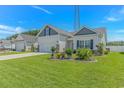Well-kept home boasts lush green lawn and landscaped garden beds, enhancing its curb appeal at 223 Lakota Loop, Longs, SC 29568