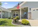 Inviting front entrance with manicured landscaping, decorative brick accents, and an American flag at 236 Palm Cove Circle, Myrtle Beach, SC 29588