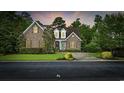 Charming brick home with manicured lawn, mature trees, and welcoming blue front door at 28 Grey Moss Rd., Murrells Inlet, SC 29576