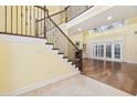 Elegant foyer features a grand staircase with decorative wrought iron railing and hardwood floors at 28 Grey Moss Rd., Murrells Inlet, SC 29576