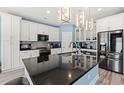 Modern kitchen with white cabinets, stainless steel appliances, a large island, and stylish lighting at 2885 Desert Rose St., Little River, SC 29566