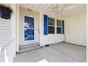 Covered front porch with blue door and storm door, and a ceiling fan at 333 Walden Lake Rd., Conway, SC 29526