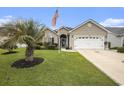 Beautiful one-story home features a lush lawn, a palm tree, and a two-car garage at 388 Sea Turtle Dr., Myrtle Beach, SC 29588