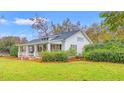 Side view of a charming home, highlighting the well-manicured landscaping and inviting front porch at 3930 West Marion St., Mullins, SC 29574