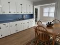 A view of the kitchen with a dining table and adjacent room with a window at 404 E Andrews St., Hemingway, SC 29554