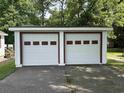 A two-car detached garage with white doors and trim accents the home at 404 E Andrews St., Hemingway, SC 29554