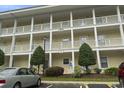 Close up on the condo building with parking, landscaping, and a sign at 4261 Hibiscus Dr. # 4-104, Little River, SC 29566