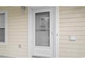 Front door with glass decorations, a screen door, a window, and cream-colored siding at 4261 Hibiscus Dr. # 4-104, Little River, SC 29566