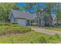 Attractive home with tidy landscaping, attached garage, and mature trees at 4532 Spyglass Dr., Little River, SC 29566