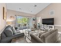 Bright living room with vaulted ceilings, a ceiling fan, sliding glass doors to a balcony, and a view of the bedroom at 4655 Wild Iris Dr. # 41-303, Myrtle Beach, SC 29577
