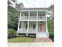 Inviting two-story home with double porches, white railings, and a striking pink front door at 55 Pineberry Dr., Georgetown, SC 29440