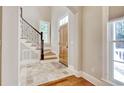 Inviting foyer with stone tile flooring, wood door, and a staircase with decorative iron railings at 55 Pineberry Dr., Georgetown, SC 29440