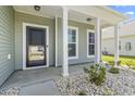 Inviting front porch with white columns and a pathway adorned with white stones and greenery at 597 Heritage Downs Dr., Conway, SC 29526