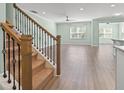 Bright and airy living room with hardwood floors, a ceiling fan, and staircase with decorative iron spindles at 597 Heritage Downs Dr., Conway, SC 29526