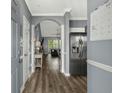 Bright hallway featuring wood floors, stainless steel refrigerator, and arched doorway at 6015 Catalina Dr. # 932, North Myrtle Beach, SC 29582