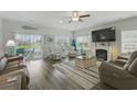 Bright living room with a fireplace, wood floors, and comfortable seating with a view of the pond at 668 Rycola Circle, Surfside Beach, SC 29575