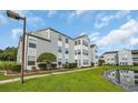 The condo features well-manicured landscaping, green grass and a view of the pond at 8658 Southbridge Dr. # L, Myrtle Beach, SC 29575