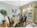 Elegant dining room featuring hardwood floors, a classic chandelier, and a window with floral curtains at 100 Culpepper Way # 1003, Myrtle Beach, SC 29579