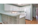 Bright kitchen with white cabinets and appliances and a breakfast bar at 1125 Blue Stem Dr. # 29F, Pawleys Island, SC 29585