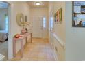 Inviting hallway with tile flooring, a decorative mirror, and a stylish table with a floral arrangement at 118 Birch N Coppice Dr. # 6, Surfside Beach, SC 29575