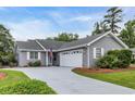 Charming gray home with white garage door, landscaped yard, concrete driveway, and an American flag at 1206 Formby Ct., Myrtle Beach, SC 29588